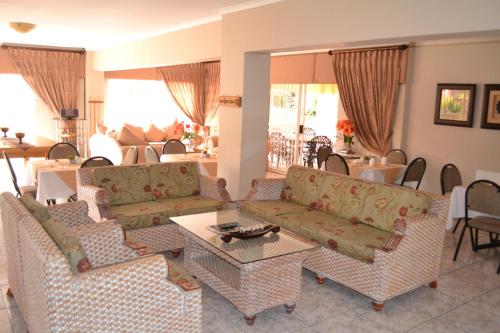 a living room with couches and a table at Eagles Nest Lodge in Johannesburg