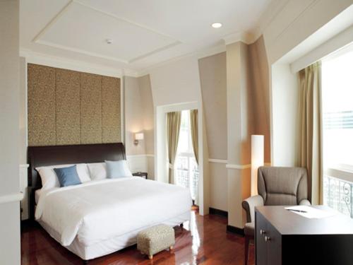 a bedroom with a bed and a desk and a chair at Aurum The River Place in Bangkok