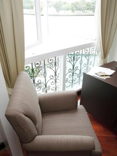a living room with a chair and a window at Aurum The River Place in Bangkok