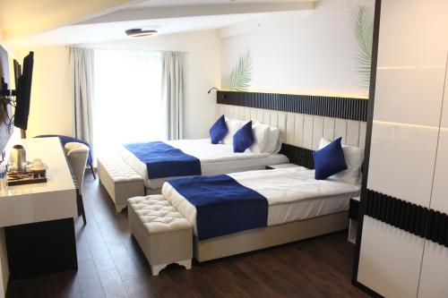 a hotel room with two beds and a table at Kavala Hotel in Bursa