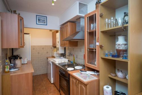 a kitchen with wooden cabinets and a stove top oven at Apartman Ljubica in Daruvar