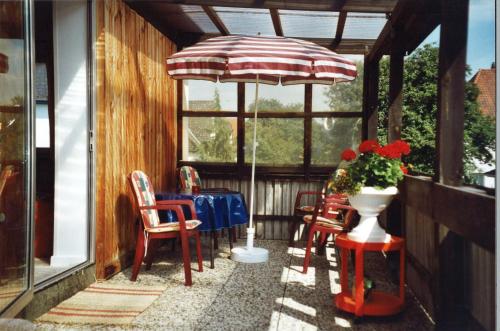 a patio with an umbrella and a table and chairs at von Frieling in Soltau
