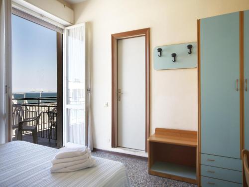 a bedroom with a bed and a balcony at Hotel Telstar in Rimini