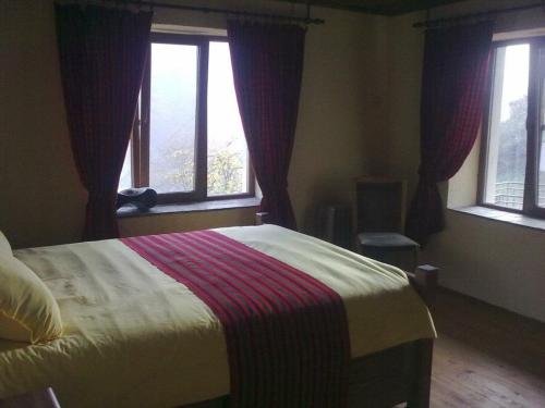 a bedroom with a bed and two windows at Zinca's Cottage in Ogled