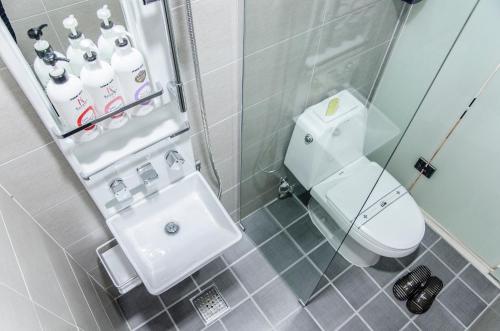 La salle de bains est pourvue de toilettes blanches et d'un lavabo. dans l'établissement Ekonomy Haeundae Hostel, à Busan