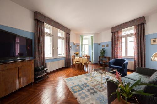 ein Wohnzimmer mit einem Sofa und einem TV in der Unterkunft Mondial Appartement Hotel in Wien