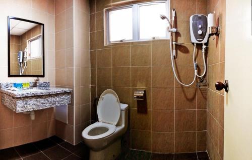 a bathroom with a toilet and a shower at Tiara Desaru Resort in Desaru