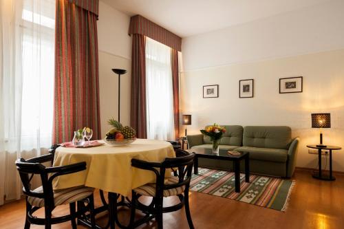 salon ze stołem i kanapą w obiekcie Mondial Appartement Hotel w Wiedniu