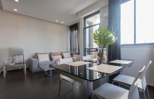 - un salon avec une table, des chaises et un canapé dans l'établissement Luxury Penthouse 2 bed near Rothchild, à Tel Aviv