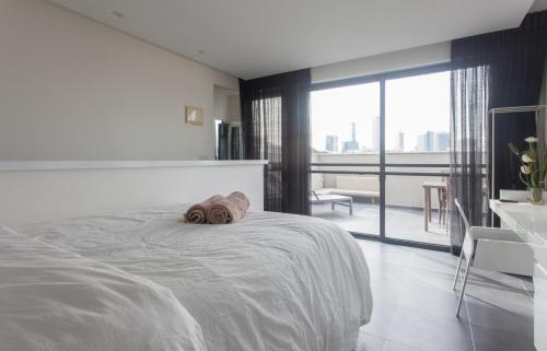 a white bedroom with a dog laying on a bed at Luxury Penthouse 2 bed near Rothchild in Tel Aviv