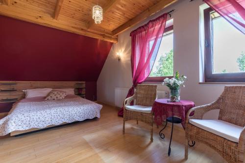 a bedroom with a bed and a table and chairs at Villa Bezycer in Gowidlino