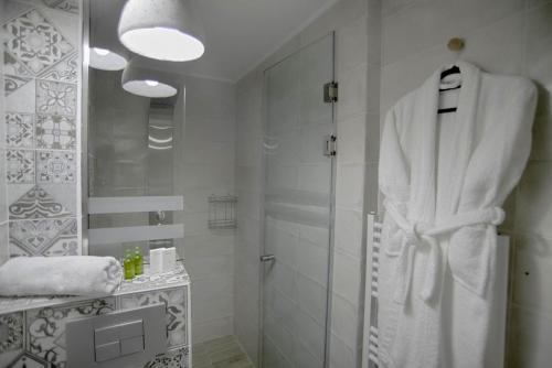 a bathroom with a shower and a white robe at Sali Boutique hotel in Alexandroupoli