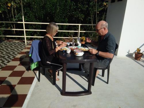 a man and woman sitting at a table eating food at EAST STAVANGER in Anaviratty