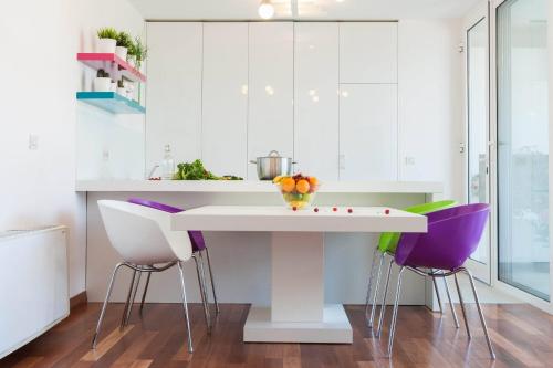 a kitchen with a white table and purple chairs at White Towers Residences in Zadar