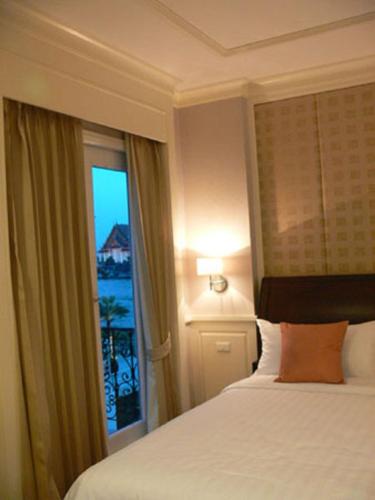a hotel room with a bed and a window at Aurum The River Place in Bangkok
