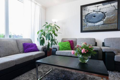 a living room with two couches and a table with flowers at White Towers Residences in Zadar