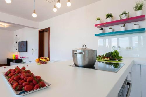 a kitchen with a plate of strawberries on a counter at White Towers Residences in Zadar