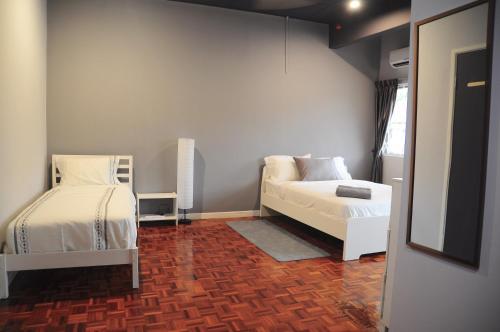 ペタリンジャヤにあるGRAYHAUS Residenceのベッド2台とソファのある小さな部屋