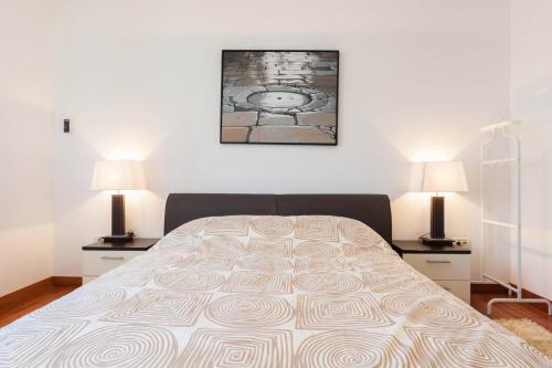 1 dormitorio con 1 cama grande y 2 lámparas en White Towers Residences, en Zadar
