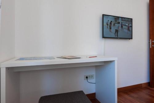 a white table with a tv on a wall at White Towers Residences in Zadar