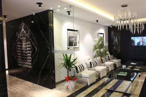 a salon with white chairs and a black wall at Kavala Hotel in Bursa