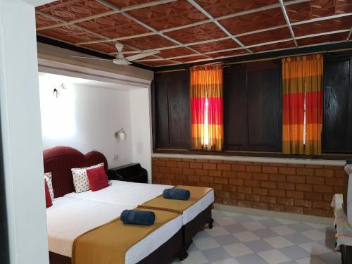 a bedroom with two beds and colorful curtains at Kairali Palace Home Stay in Thekkady