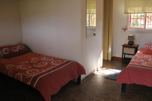 1 dormitorio con 2 camas y ventana en Rooisand Desert Ranch en Chausib