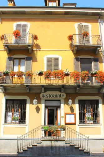 a yellow building with balconies and flowers on it at Locanda Piemonte da Sciolla in Domodossola