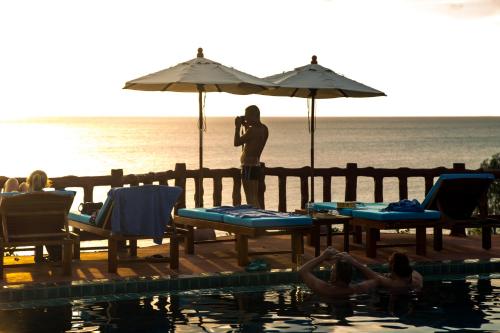 a man taking a picture of a group of people by a pool at Zama Resort Koh Phangan in Haad Chao Phao