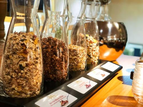 a group of glass containers filled with different types of granola at IMPULSIV Hotel & Sportresort in Lörrach