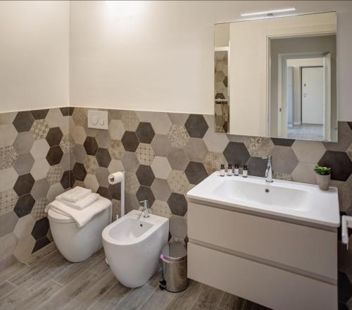 a bathroom with a sink and a toilet and a mirror at QUADRATO in Turin