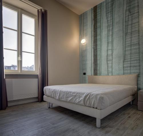 a bedroom with a bed and two windows at QUADRATO in Turin