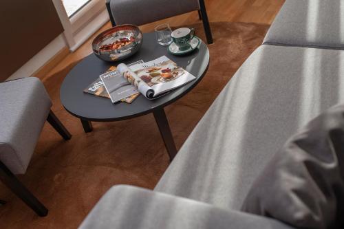 a table with a magazine and a bowl on it at Fontana Hotel & Gastronomy in Budva