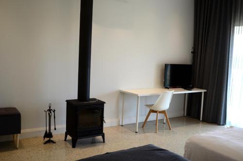 a room with a stove and a desk and a bed at Rooks Edge in Gisborne