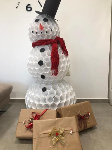 a snowman with a top hat next to a box at Boró Apartman in Tiszafüred