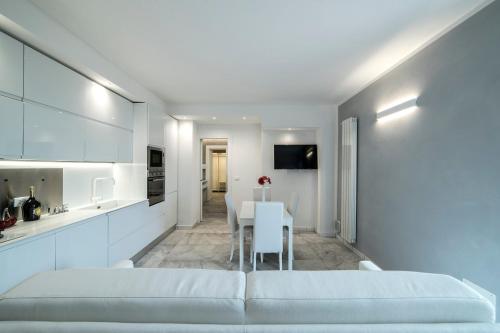 a white bedroom with a white couch and a table at Rocca Palazzaccio in Impruneta