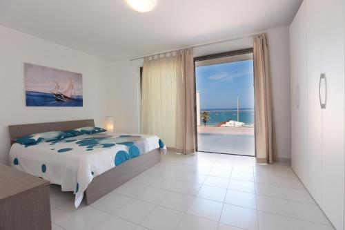 a bedroom with a bed and a view of the ocean at Il Gabbiano - Case Vacanze in Capo dʼOrlando
