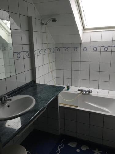 La salle de bains est pourvue d'un lavabo et d'une baignoire. dans l'établissement gite du chêne, à Bierne