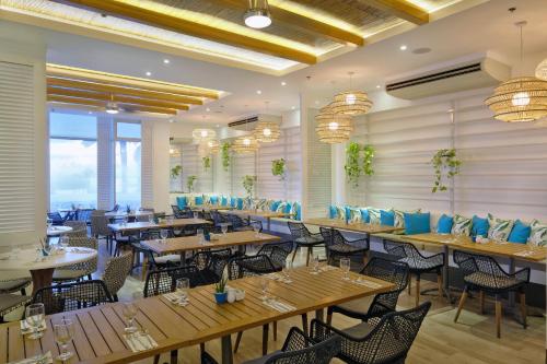 a restaurant with wooden tables and chairs at BE Resort Mactan in Mactan