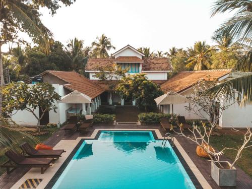 a villa with a swimming pool in front of a house at Handun Villas in Talalla