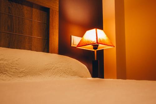 a lamp sitting next to a bed in a room at Hotel Cemar in Mondariz