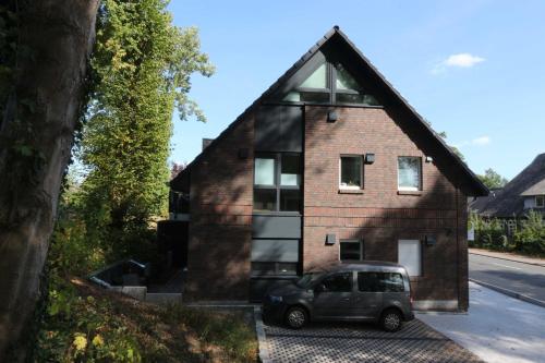 um carro estacionado em frente a uma casa de tijolos em Landhaus Lueneburg little luxury em Lüneburg