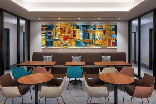 a restaurant with tables and chairs and a painting on the wall at Park Inn by Radisson Berlin Alexanderplatz in Berlin