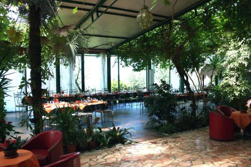 a restaurant with tables and chairs and plants at Hotel 5 Terre Nel Sole in Deiva Marina