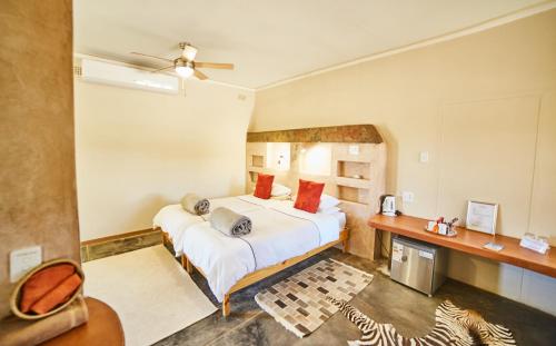 um quarto com 2 camas e uma ventoinha de tecto em BuellsPort Naukluft Lodge & Farm em Naukluft Mountains