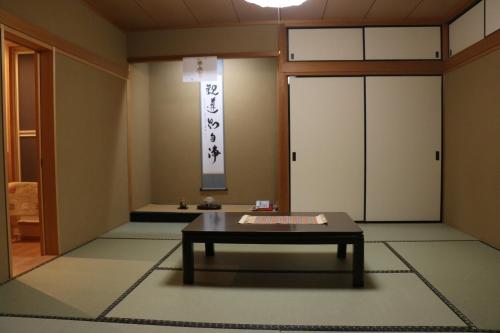 a room with a table in front of a door at Gyokuzoin in Heguri