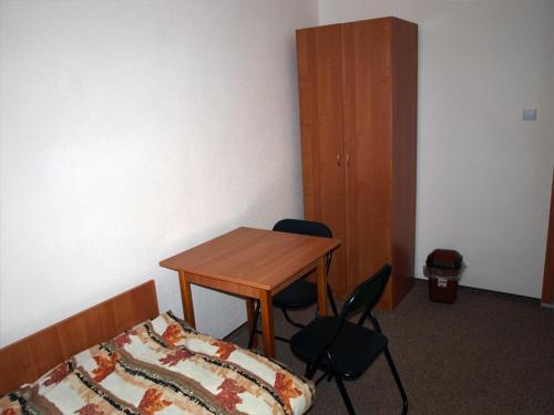 a bedroom with a bed and a table and chairs at Hostel Hutnik in Ostrowiec Świętokrzyski