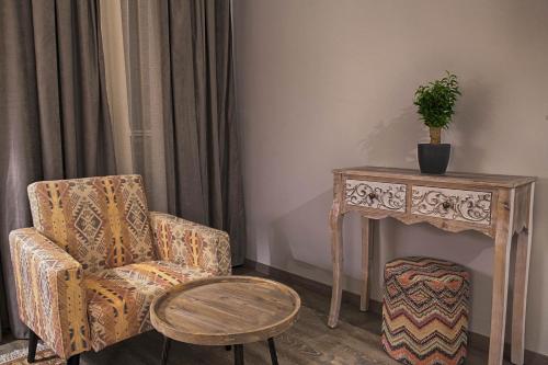 a living room with a chair and a table at Sali Boutique hotel in Alexandroupoli