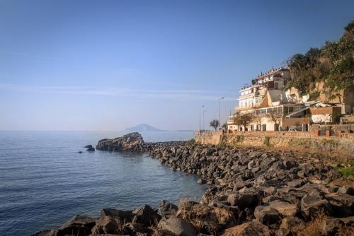 un gruppo di case su una collina rocciosa vicino all'acqua di Accasarte P01 a Napoli