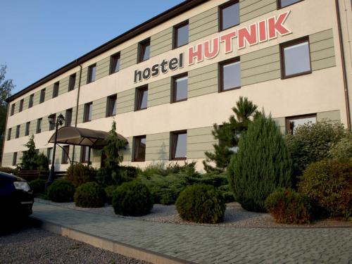 un hotel con un cartel en el lateral de un edificio en Hostel Hutnik, en Ostrowiec Świętokrzyski